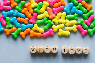 Inscription with love next to a lot of unusual brightly coloured joke souvenirs - lollipops. Humorous congratulations on valentine's day. Joke and sarcasm. Photo