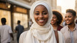 Beautiful charming young Middle Eastern Muslim woman wearing a hijab posing on the streets of a city at sunset looking very happy with hope and peaceful mind