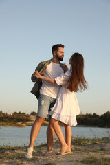 Poster - Beautiful couple dancing near river at sunset