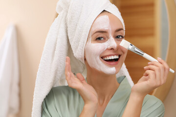 Wall Mural - Woman applying face mask indoors. Spa treatments