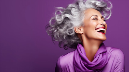 Wall Mural - Beautiful woman with grey hair laughing and developing her hair on a purple background