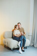 © DSMT - Happy young family with a newborn baby. Beautiful mother and father kissing their child. Parents and smiling child in arms, isolated over white background.