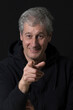 portrait of a mature man pointing his finger in a low key image
