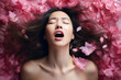 © Magryt - Young Asian woman having orgasm. Beautiful woman with open mouth and closed eyes enjoying sex lying among flower petals. Sexual experience, getting sexual pleasure, masturbation, cunnilingus