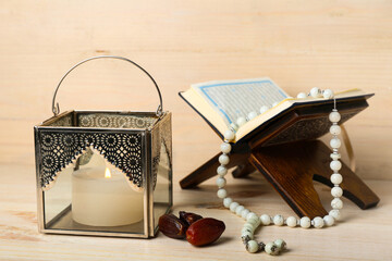 Wall Mural - Muslim lamp with burning candle, dates, Koran and prayer beads on light wooden background