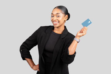 Smiling confident millennial black businesswoman hold credit card