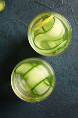 Wall Mural - Glasses of infused water with cucumber slices on dark table