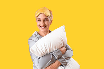 Sticker - Mature woman in pajamas with pillow on yellow background