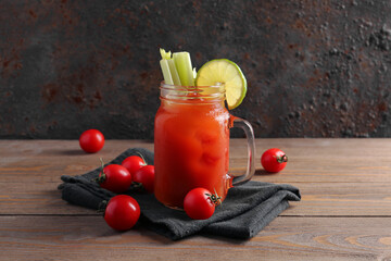 Fototapeta mason jar of bloody mary with celery and lime on wooden table