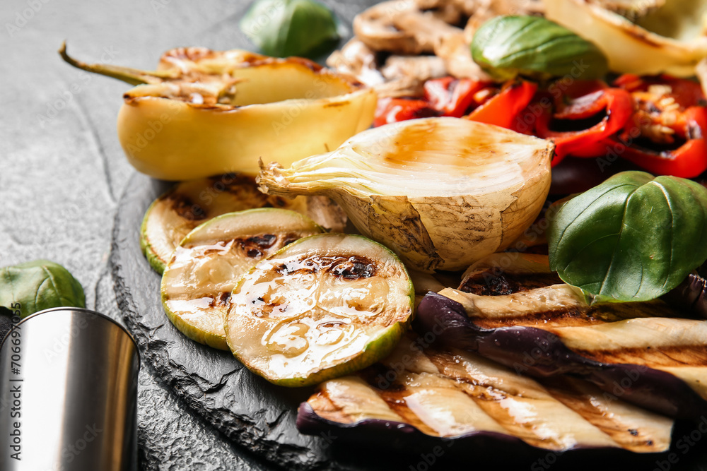 Board with tasty grilled vegetables on blue background