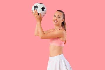 Wall Mural - Happy beautiful young sporty woman with soccer ball on pink background