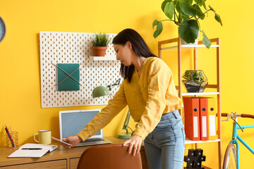 Young Asian woman with mobile phone at home office