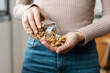 © nenetus - Young woman hands holding a jar of nuts and dried fruits at home.