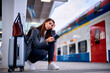 Young pensive woman at train station platform.