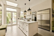 The Kitchen Has A Large Island And Stainless Steel Refrigerator