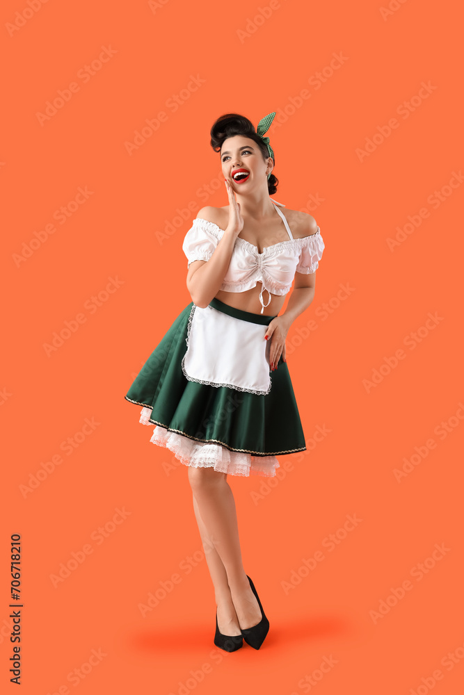 Young pin-up waitress on orange background
