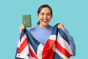 Wall Mural - Pretty young woman with UK flag and passport on blue background. Immigration concept