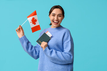 Poster - Pretty young woman with flag of Canada and passport on blue background. Immigration concept