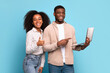 © Prostock-studio - Excited black couple with laptop showing thumbs up on blue