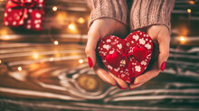 Hands cradling a heart shaped Valentine gift box