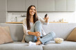 © Prostock-studio - Delighted female with bowl of popcorn at home watching her favorite shows