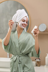 Canvas Print - Woman applying face mask in bathroom. Spa treatments