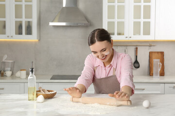 Happy woman with soiled face cooking at messy table in kitchen