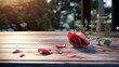 Withered pink flower with its petals falling on a wooden table in the garden - copyspace