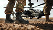 solder with black combat boots standing in front of helicopter