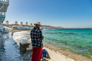 Wall Mural - Local fisherman and Famous windmills of Mykonos island, Greece