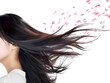 風に舞う花びらと美しい髪のアジア系女性