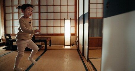 Happy, home and Japanese girl in a family house running for game, fun and playing. Young child, morning and excited in a living room with sliding door from Japan with youth activity and smile of kid