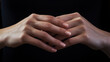 Beautifully groomed woman's hands against a black background.