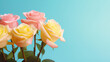 © tashechka - A bouquet of delicate pastel pink and yellow roses set against a soft blue background, symbolizing gentleness and affection.