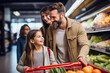 © TaniaC. - Una famila feliz de compras en el supermercado adquiriendo productos frescos de frutas y verduras.