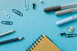 top view of school stationery with notepad over blue