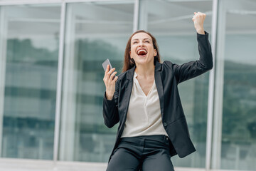 business woman with mobile phone and expression of success