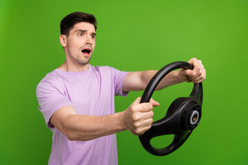 Poster - Portrait of astonished person wear t-shirt staring at accident empty space steering wheel in arms isolated on green color background