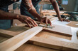 © Prins Productions - Close up of an African male lining up a piece of wood for carpentry project in woodwork factory
