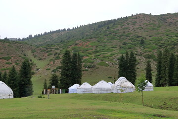 Wall Mural - landscape near Jeti Oguz gorge with yurts and green meadows on a cloudy day