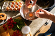 © Marko Geber - Woman cracking an egg into a bowl for cooking at home kitchen