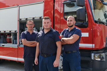 A skilled and dedicated professional firefighting team proudly poses in front of their state of the art firetruck, showcasing their modern equipment and commitment to ensuring public safety.