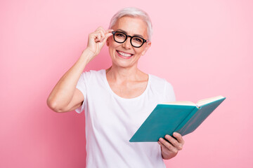 Canvas Print - Photo of cheerful positive woman with short hairstyle wear white t-shirt touch glasses read interesting book isolated on pink background