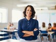 © Svetlana - smiling teacher standing in classroom with arms crossed.