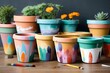 A set of DIY painted plant pots, each featuring a unique design created by a child.