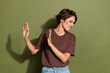 Portrait of upset woman with short hair wear oversize t-shirt stay out of disgusting smelly object isolated on green color background