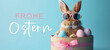 Frohe Ostern Konzept Feiertag Grußkarte mit deutschem Text - Cooler Osterhase, Kaninchen mit Sonnenbrille, sitzt in Geschenkbox mit Ostereiern, isoliert auf blauem Hintergrund