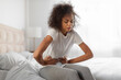 © Prostock-studio - Unhappy black woman touching belly having painful menstrual cramps indoor