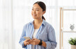© Prostock-studio - Interested korean lady with smartphone in her hands, copy space