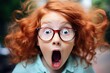 a red hair child in glasses looking surprised.
